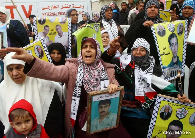 Palestinians hold pictures of their prisoned relatives in Israeli jails as they gather in a weekly activity calling for their liberty at the Red Cross headquarters. 6th February 2012. Photo by Ashraf Amra