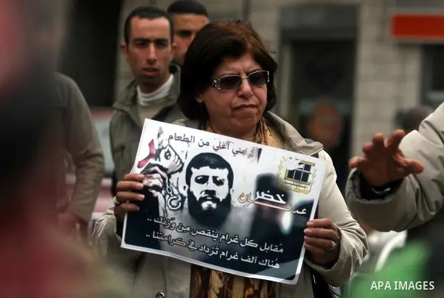 Palestinians hold images of prisoner Khader Adnan, who has been on hunger strike since December 18 while being held in an Israeli jail, during a protest in the West Bank city of Ramallah on February 6, 2012. Adnan, repor...