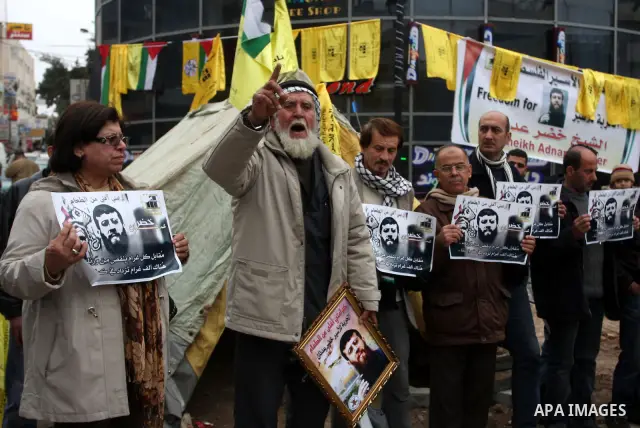 Palestinians hold images of prisoner Khader Adnan, who has been on hunger strike since December 18 while being held in an Israeli jail, during a protest in the West Bank city of Ramallah on February 6, 2012. Adnan, repor...