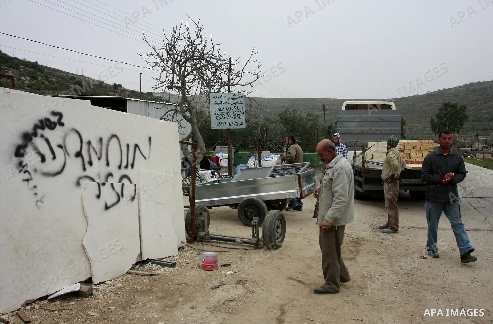 A Palestinian man looks at graffiti sprayed in the West Bank village near Nablus, Feb. 07, 2012. Palestinians say that Jewish extremists had been found on the streets of the village and the man fled, and two Jewish women...