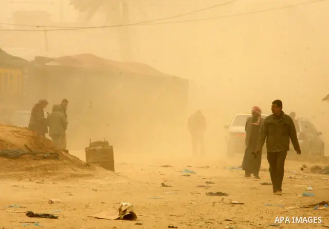 Palestinians walk at a street during cold winds and sand storms in the southern Gaza Strip town of Rafah on February 7, 2012. Photo by Abed Rahim Khatib