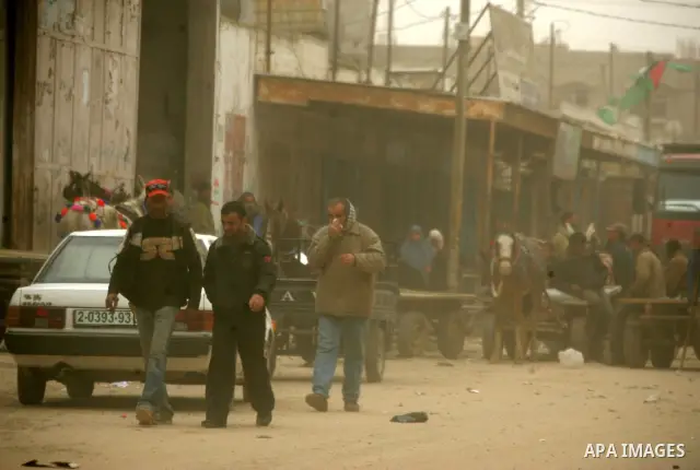 Palestinians walk at a street during cold winds and sand storms in the southern Gaza Strip town of Rafah on February 7, 2012. Photo by Abed Rahim Khatib