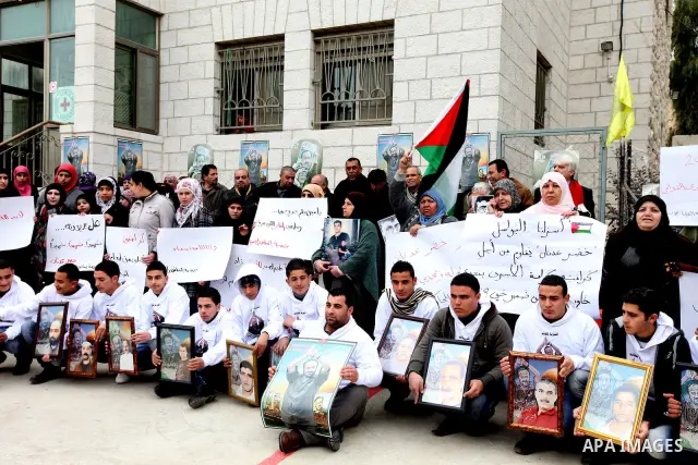 Families of Palestinian prisoners, held in Israeli jails, hold their relatives pictures during a protest in front of the International Committee of the Red Cross (ICRC) offices in the West Bank town of Ramallah, 07 Febru...