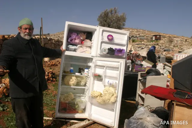 Palestinians collect their belongings after their house was demolished by Israeli bulldozers in the Arab east Jerusalem neighbourhood of Beit Hanina on February 9, 2012. Israel regularly demolishes homes in Arab east Jer...