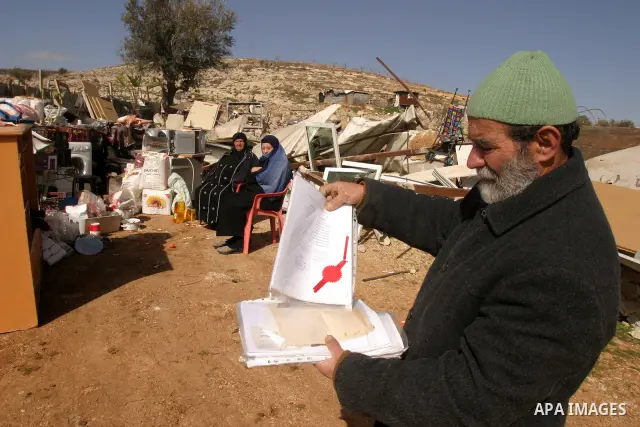 Palestinians collect their belongings after their house was demolished by Israeli bulldozers in the Arab east Jerusalem neighbourhood of Beit Hanina on February 9, 2012. Israel regularly demolishes homes in Arab east Jer...