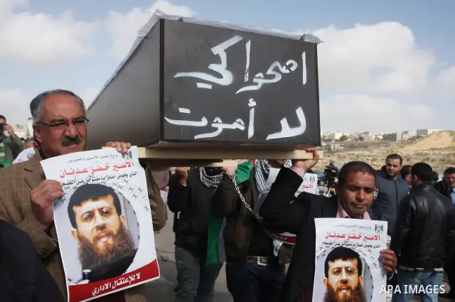 Palestinian protesters hold a mock coffin with the Arabic writing "wake up so that I will not die" as they demonstrate outside the Israeli Ofer military prison, near the West Bank town of Betunia, on February 9, 2012 aga...