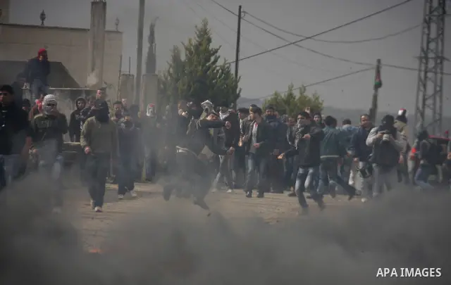 Palestinians protester runs through a cloud of teargas fired by Israeli soldiers during a demonstration against the expropriation of Palestinian land by Israel in the village of Kfar Qaddum, near the West Bank city of Na...