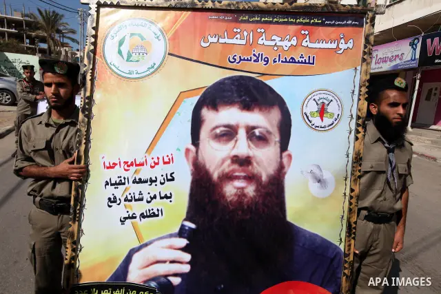 Palestinians scouts hold images of prisoner Khader Adnan, who has been on hunger strike since December 18 while being held in an Israeli jail, during a protest Gaza City, on Feb. 11, 2012. Photo by Majdi Fathi