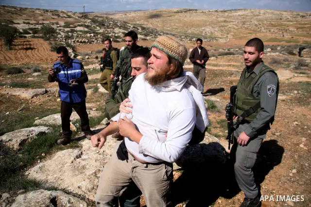 A Jewish settler (c) from the Susia Israeli settlement argues with Israeli soldiers after a donkey was used by Palestinian farmers to transport trees to be planted on their land close to Susia village, in the Israeli occ...