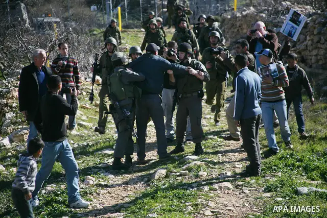 Israeli soldiers arrest a demonstrator during scuffles with Palestinians in a weekly protest against Israel's controversial separation barrier in the West Bank village of Beit Omar, close to city of Hebron and the settle...