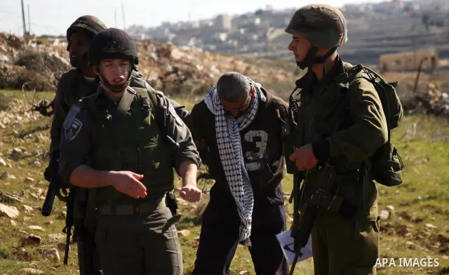 Israeli soldiers arrest a demonstrator during scuffles with Palestinians in a weekly protest against Israel's controversial separation barrier in the West Bank village of Beit Omar, close to city of Hebron and the settle...