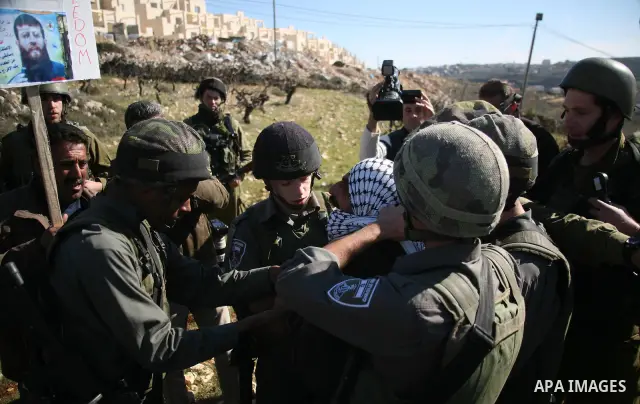 Israeli soldiers arrest a demonstrator during scuffles with Palestinians in a weekly protest against Israel's controversial separation barrier in the West Bank village of Beit Omar, close to city of Hebron and the settle...