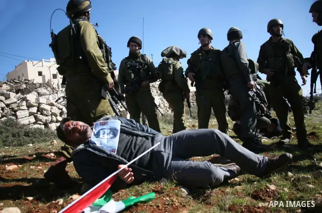 Israeli soldiers arrest a demonstrator during scuffles with Palestinians in a weekly protest against Israel's controversial separation barrier in the West Bank village of Beit Omar, close to city of Hebron and the settle...