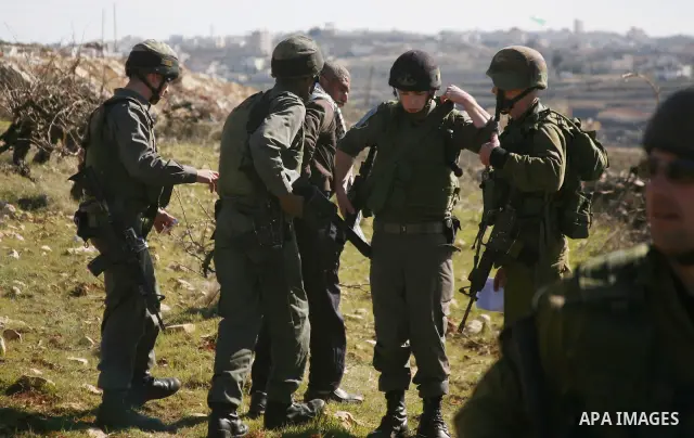 Israeli soldiers arrest a demonstrator during scuffles with Palestinians in a weekly protest against Israel's controversial separation barrier in the West Bank village of Beit Omar, close to city of Hebron and the settle...