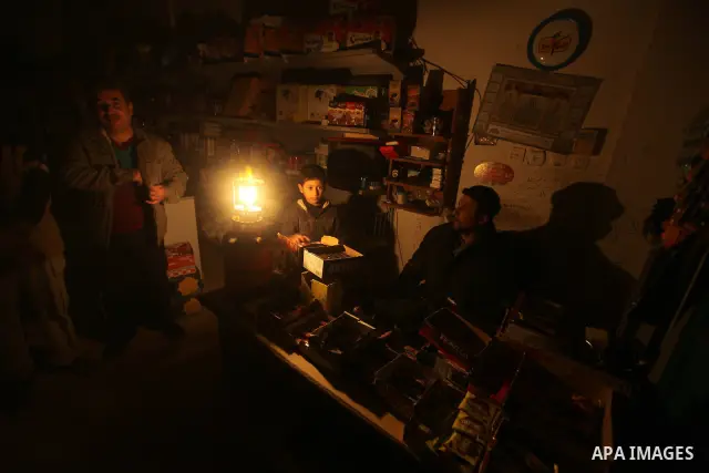 A Palestinian vendor sits at his shop at the Shati refugee camp in Gaza City during a power cut on February 11, 2012. The Gaza energy authority announced that if fuel doesn't enter the coastal enclave, the Gaza Strip wil...
