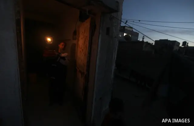 Palestinian man sit at his home during a power cut at the Shati refugee camp in Gaza City on February 11, 2012. The Gaza energy authority announced that if fuel doesn't enter the coastal enclave, the Gaza Strip will face...