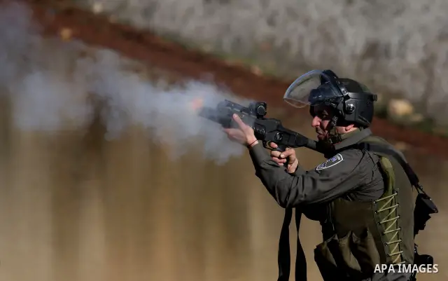 Israeli troops fire tear gas towards Palestinian demonstrators during a protest outside the Ofer military prison in support of Khader Adnan, 33, a senior member of Islamic Jihad jailed in Israel who has been on a hunger...