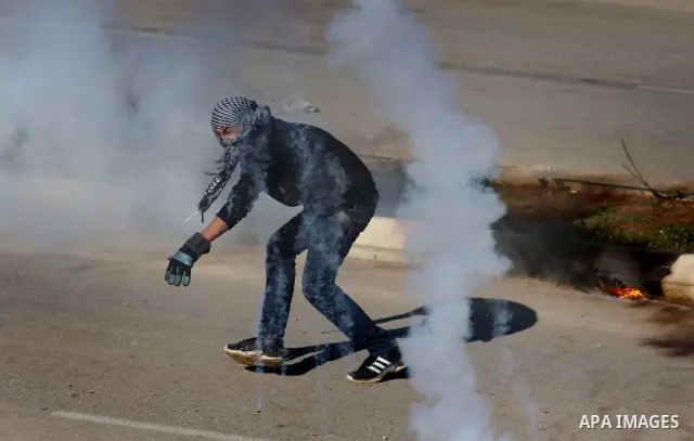 Palestinian protesters clash with Israeli troops fire tear gas during a protest outside the Ofer military prison in support of Khader Adnan, 33, a senior member of Islamic Jihad jailed in Israel and who has been on a hun...
