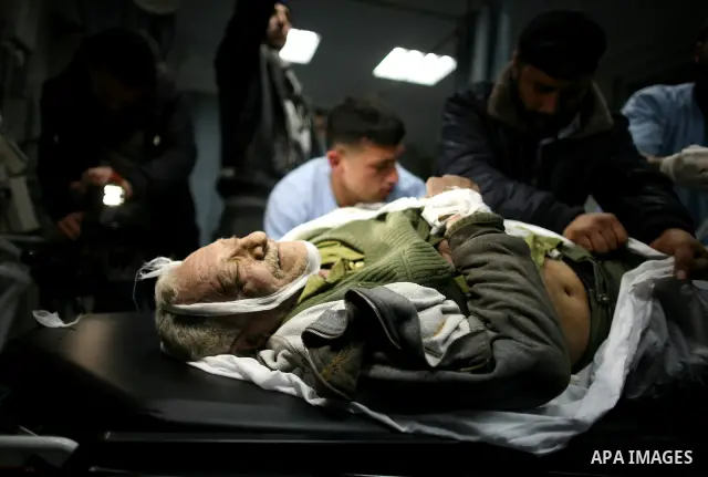 Palestinian medical workers examine the body of Abdelkarim Zaytoniya, a 75-year-old who was killed in Israeli aerial bombing, at al-Shefa hospital in Gaza City, Feb. 12, 2012. A Palestinian was killed and two others were...