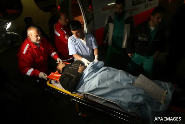 Palestinian paramedics wheel a wounded police officer at the Shifa hospital after an Israeli air strike in Gaza City on 12 February 2012. The air strikes came in response to a short-range rocket that was launched from Ga...