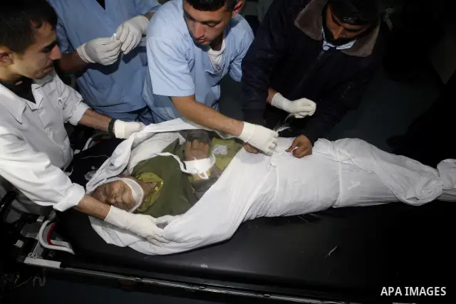 Palestinian medical workers examine the body of Abdelkarim Zaytoniya, a 75-year-old who was killed in Israeli aerial bombing, at al-Shefa hospital in Gaza City, Feb. 12, 2012. A Palestinian was killed and two others were...