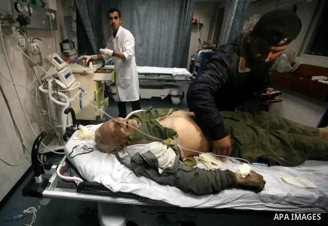 Palestinian medical workers examine the body of Abdelkarim Zaytoniya, a 75-year-old who was killed in Israeli aerial bombing, at al-Shefa hospital in Gaza City, Feb. 12, 2012. A Palestinian was killed and two others were...