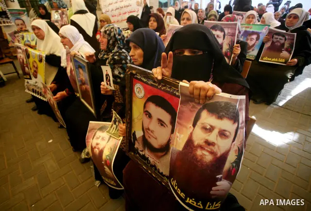 Palestinian women hold posters depicting Palestinian prisoner Khader Adnan, a member of the Islamic Jihad militant group, during a protest in Gaza City, calling for the release of Palestinian prisoners from Israeli jails...