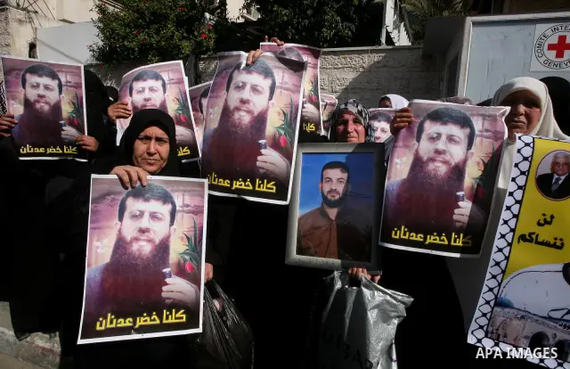 Palestinian women hold posters depicting Palestinian prisoner Khader Adnan, a member of the Islamic Jihad militant group, during a protest in Gaza City, calling for the release of Palestinian prisoners from Israeli jails...