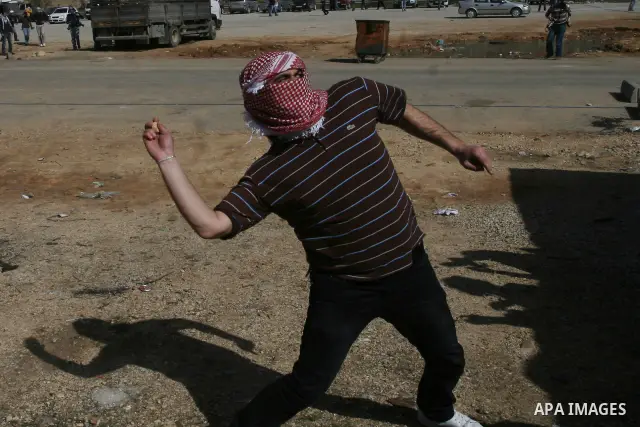 Palestinian protesters hurls stones at Israel security forces during clashes outside the Ofer military prison near the West Bank city of Ramallah, Monday, Feb. 13, 2012. Clashes between dozens of Palestinians and Israeli...