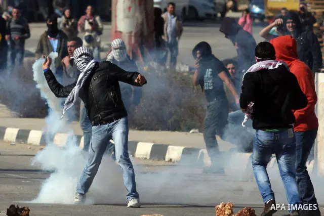 Palestinian protesters hurls stones at Israel security forces during clashes outside the Ofer military prison near the West Bank city of Ramallah, Monday, Feb. 13, 2012. Clashes between dozens of Palestinians and Israeli...