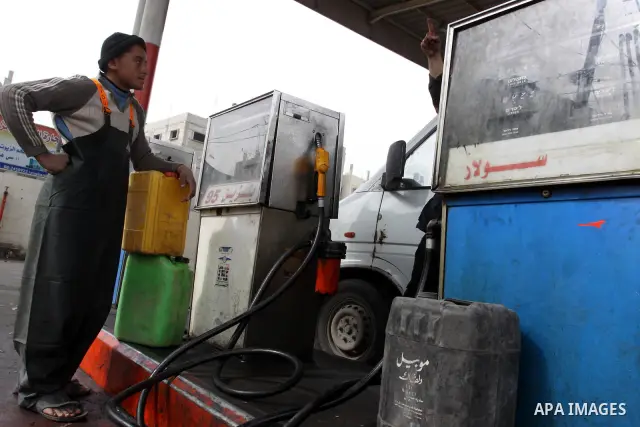 Palestinians wait to fill containers with fuel from a petrol station in Gaza City, on February 15, 2012, as the Palestinian authority calls on Egypt to provide more fuel. Photo by Mohammed Asad