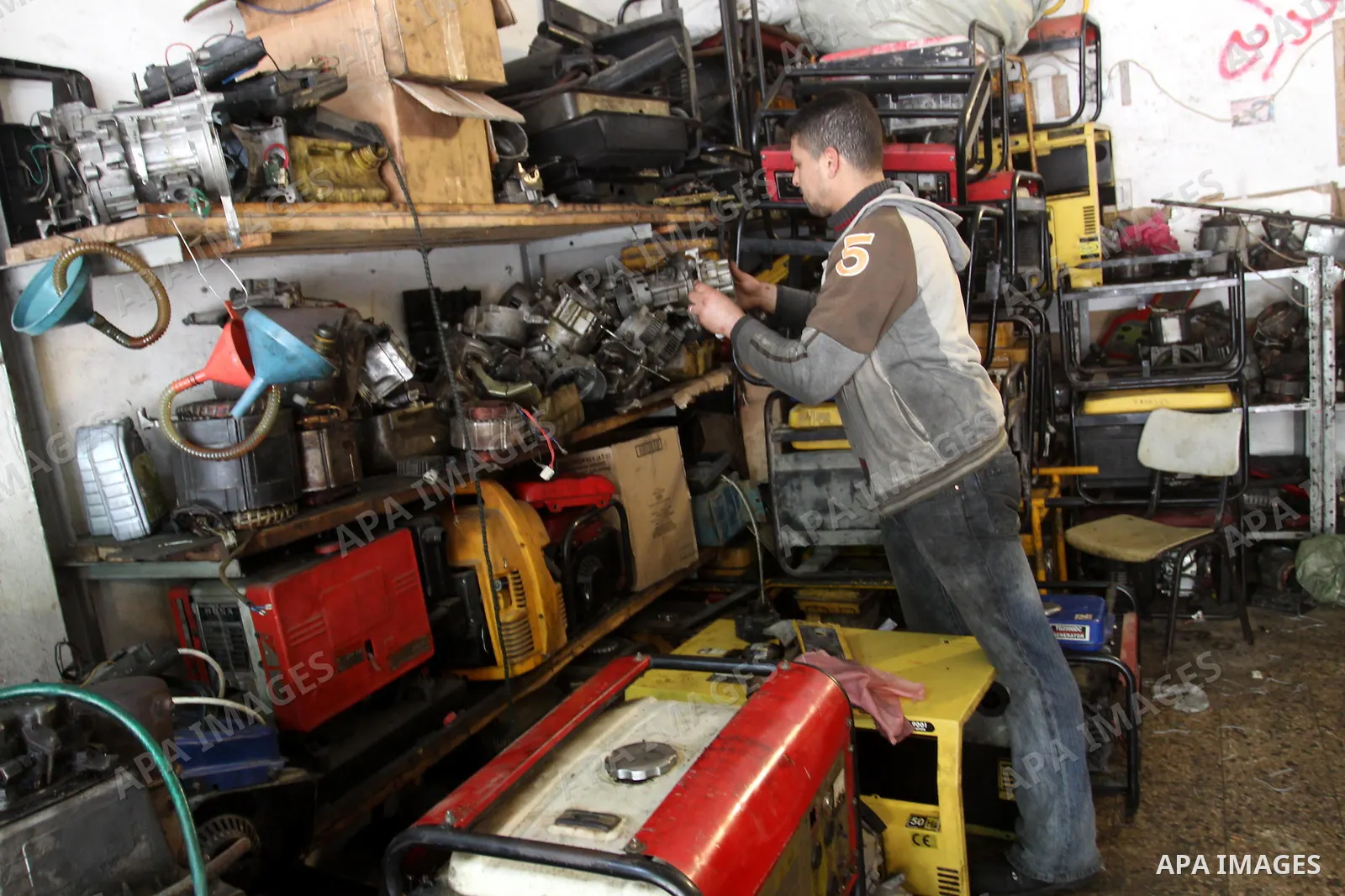 A Palestinian man fixes a generator at a shop in Gaza City, on February 15, 2012. The people of the Gaza Strip use a large number of generators because of the continuing lack of electricity in the Gaza Strip. Photo by Mo...