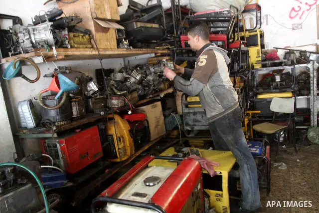 A Palestinian man fixes a generator at a shop in Gaza City, on February 15, 2012. The people of the Gaza Strip use a large number of generators because of the continuing lack of electricity in the Gaza Strip. Photo by Mo...