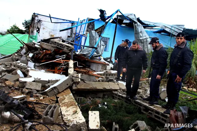 A Hamas police officer looks at the damage to a structure after an Israeli air strike in Gaza City February 16, 2012. The Israeli military said aircraft targeted two militant facilities early on Thursday in response to r...