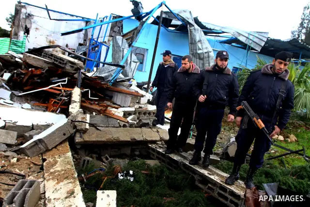 A Hamas police officer looks at the damage to a structure after an Israeli air strike in Gaza City February 16, 2012. The Israeli military said aircraft targeted two militant facilities early on Thursday in response to r...