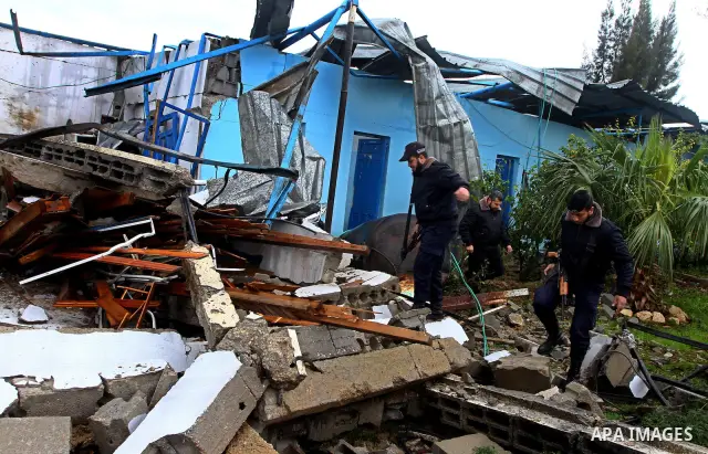 A Hamas police officer looks at the damage to a structure after an Israeli air strike in Gaza City February 16, 2012. The Israeli military said aircraft targeted two militant facilities early on Thursday in response to r...