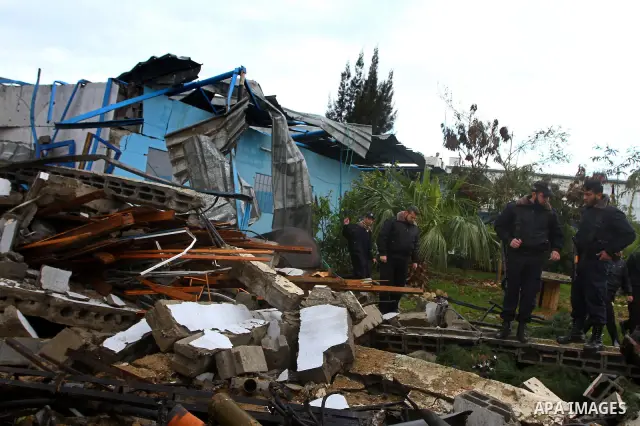 A Hamas police officer looks at the damage to a structure after an Israeli air strike in Gaza City February 16, 2012. The Israeli military said aircraft targeted two militant facilities early on Thursday in response to r...