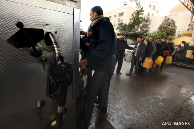 Palestinians fill containers with fuel from a petrol station in the Gaza City on 16 February 2012. Reports state that residents in the Gaza Strip flocked to petrol stations hoping to get a share of the remaining fuel, sa...