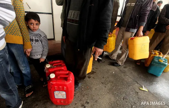 Palestinians fill containers with fuel from a petrol station in the Gaza City on 16 February 2012. Reports state that residents in the Gaza Strip flocked to petrol stations hoping to get a share of the remaining fuel, sa...