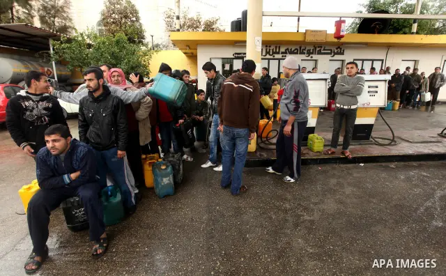 Palestinians fill containers with fuel from a petrol station in the Gaza City on 16 February 2012. Reports state that residents in the Gaza Strip flocked to petrol stations hoping to get a share of the remaining fuel, sa...