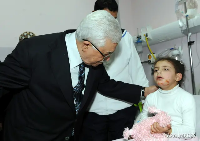 Palestinian President Mahmoud Abbas visits a Palestinian child, one of dozens of schoolchildren injured in a school bus accident, at a hospital in the West Bank city of Ramallah, Thursday, Feb. 16, 2012. A truck lost con...