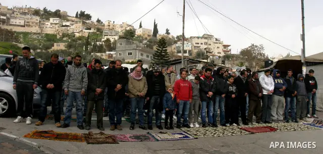 Palestinians pray on a street outside a protest tent during Friday noon prayers on 17 Feb 2012 in the Silwan neighborhood of East Jerusalem. Silwan is seen behind.. Photo by Mahfouz Abu Turk