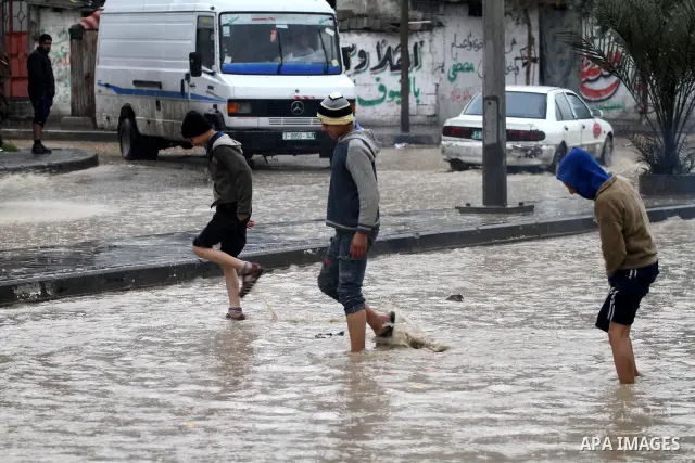 Palestinian boys walk in a street during the heavy rain of the winter, in the Gaza City, Feb. 19, 2012. Photo by Mohammed Asad