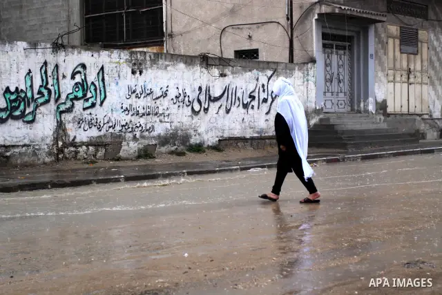 Palestinian woman walk in a street during the heavy rain of the winter, in the Gaza City, Feb. 19, 2012. Photo by Mohammed Asad