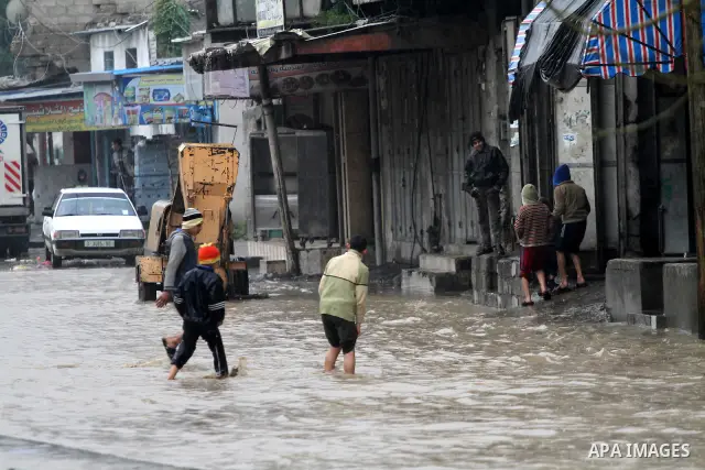 Palestinian boys walk in a street during the heavy rain of the winter, in the Gaza City, Feb. 19, 2012. Photo by Mohammed Asad