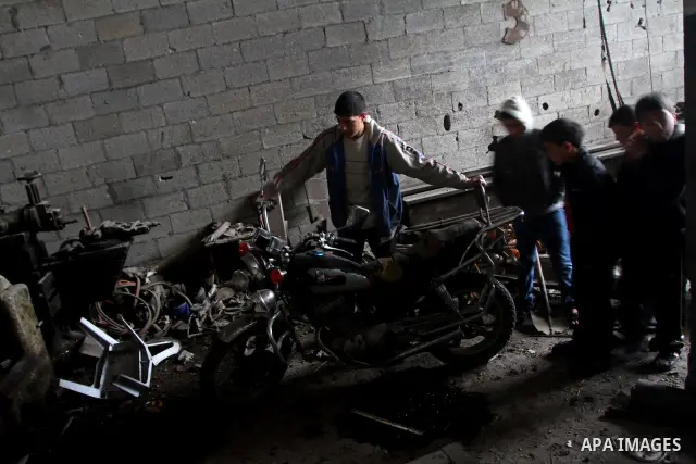 Palestinians look at what they said is a metal workshop which was damaged in an Israeli air strike on Saturday night in Gaza City February 19, 2012. Photo by Ashraf Amra