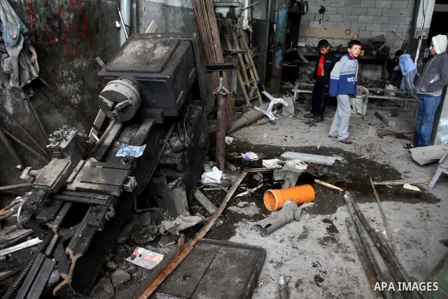 Palestinians look at what they said is a metal workshop which was damaged in an Israeli air strike on Saturday night in Gaza City February 19, 2012. Photo by Ashraf Amra