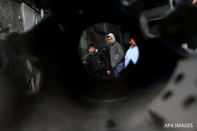 Palestinians look at what they said is a metal workshop which was damaged in an Israeli air strike on Saturday night in Gaza City February 19, 2012. Photo by Ashraf Amra
