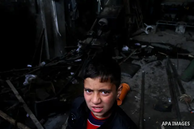 A Palestinian boy looks at what Palestinians said is a metal workshop which was damaged in an Israeli air strike on Saturday night in Gaza City February 19, 2012. Photo by Ashraf Amra