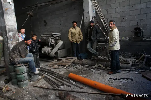 Palestinians look at what they said is a metal workshop which was damaged in an Israeli air strike on Saturday night in Gaza City February 19, 2012. Photo by Ashraf Amra